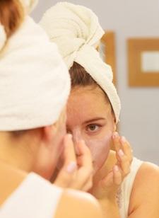 woman putting skin moisturizer on her face