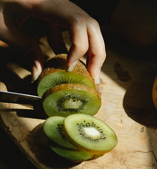 woman cutting kiwi fruit