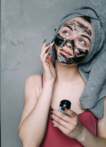 woman using a skincare treatment on her face made of activated charcoaltr