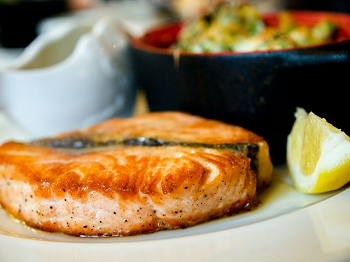 salmon plus lemon wedge and bowl of vegetables 