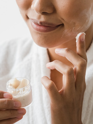 woman applying lotion to her skin