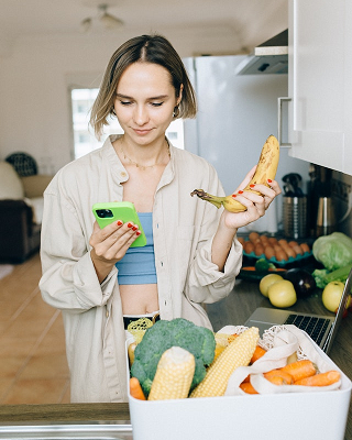 woman in her kitchen with lots of fruit and vegetables