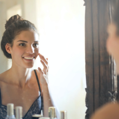 woman looking at her face in the mirror
