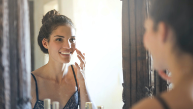 woman looking at her face in the mirror