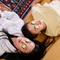two women with cucumber slices on their eyes