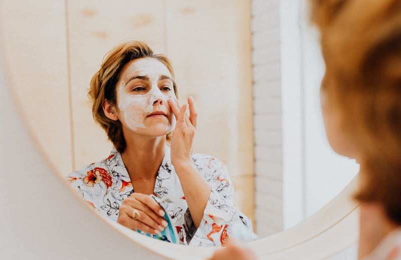 woman applying a skincare product to her face