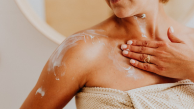 woman putting moisturizer on her skin