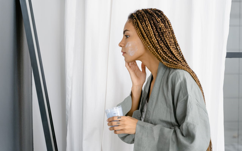 woman applying moisturizer to her face