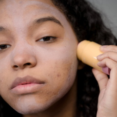 woman applying an acne skincare product to her face