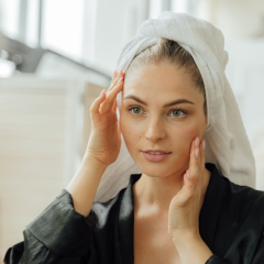 woman looking at her face in the mirror